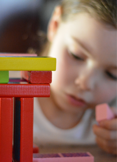 niña jugando con fichas de madera